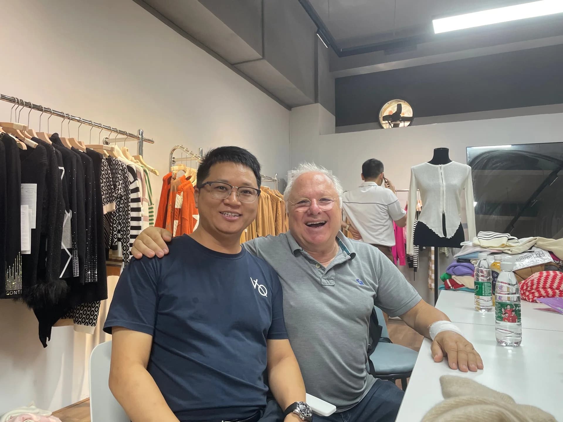 A happy buyer with our team in the knitwear showroom, sample rail behind