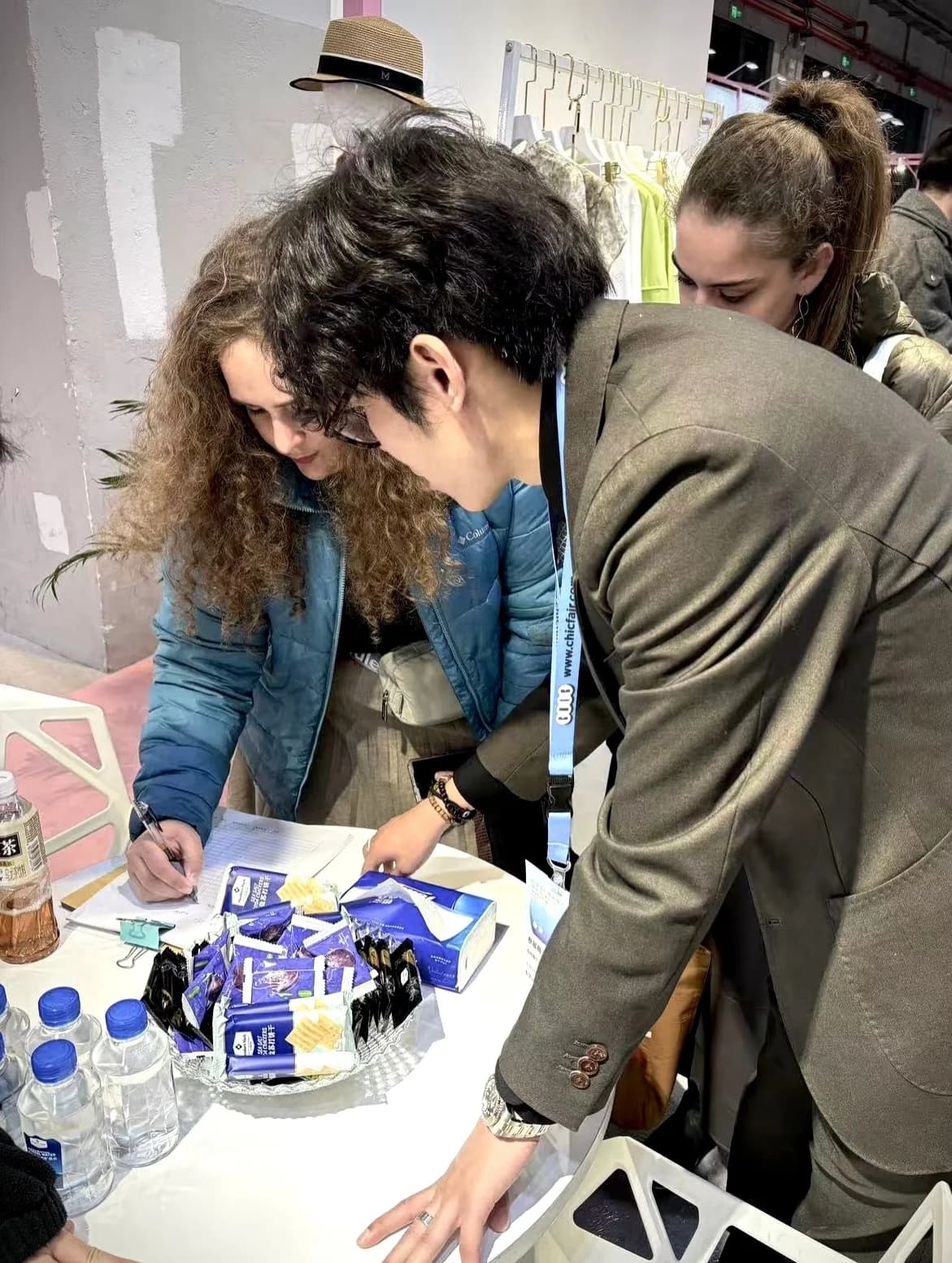 Visitors inspecting samples and packaging laid out on the display table